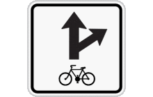 Dodatková tabulka „Povolený směr jízdy cyklistů“. Za použití odpovídajících směrových šipek vyznačuje možný směr jízdy cyklistů. TestImage